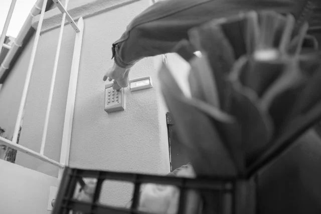 A person entering a code on a gate access keypad